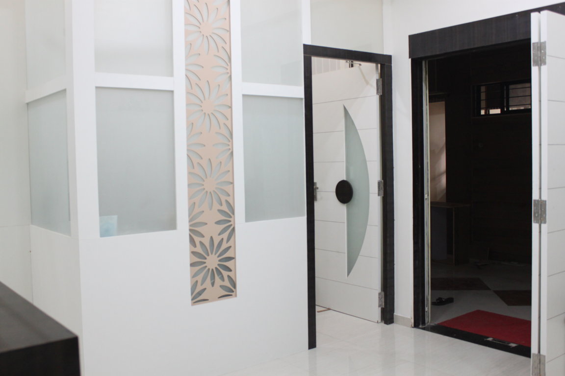 Curved frosted-glass doors leading into the Insight Institute operating wing, framed by laser-cut floral panels and a clean white corridor